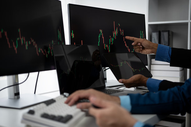 股票图表股票市场企业家讨论和分析图表。在办公室里做股票交易图片下载