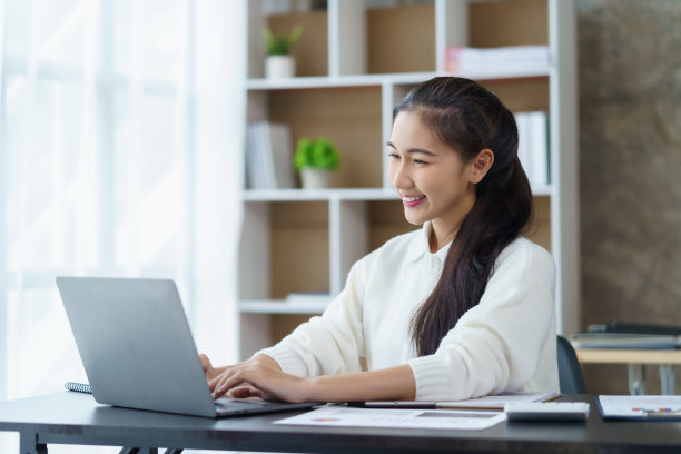 年轻漂亮的亚洲女学生在家里用笔记本电脑在线学习。图片下载