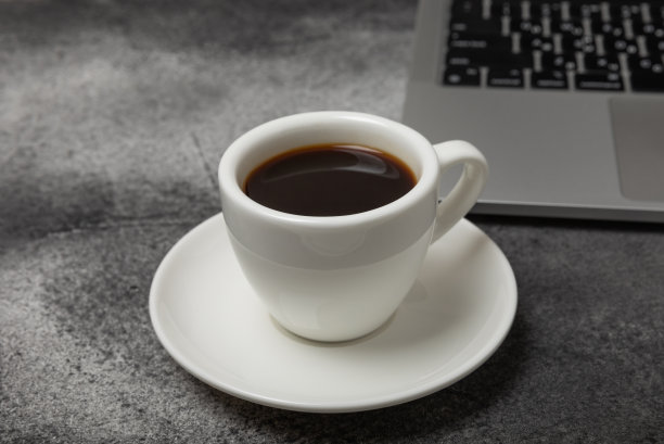 办公桌的俯视图。工作区与笔记本电脑和咖啡杯纹理黑色背景。平躺图片下载