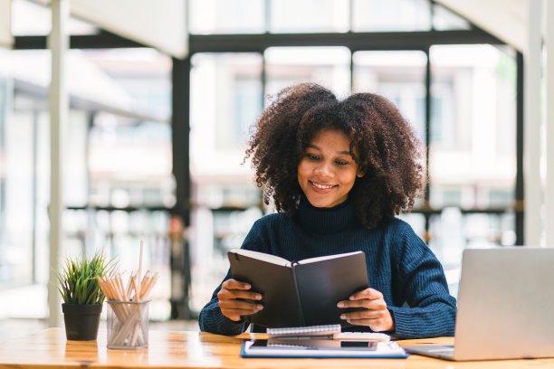 非裔美籍商人或会计，留着非洲发型，使用计算器、图表和图表分析市场数据、资产负债表、账目和净利润。图片下载