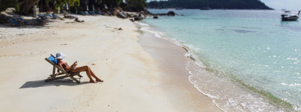 航拍照片的女人放松在热带海滩，看书和日光浴。旅游业。旅行者。图片下载