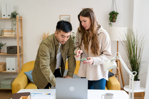 一男一女在家工作时使用手机。图片下载