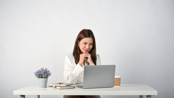 一名上班族双手合十，幸福地低头看着笔记本电脑屏幕图片下载