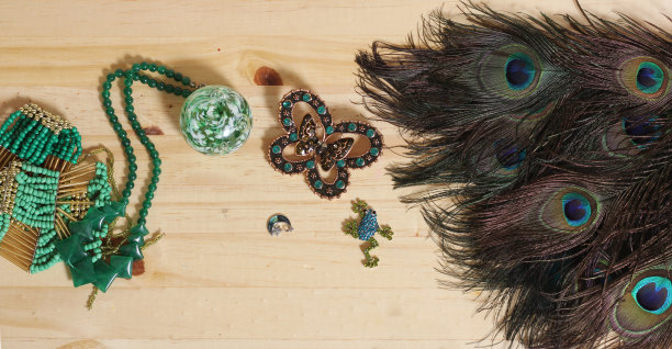 孔雀羽毛绿珠和绿铜蝴蝶胸针木背景图片下载