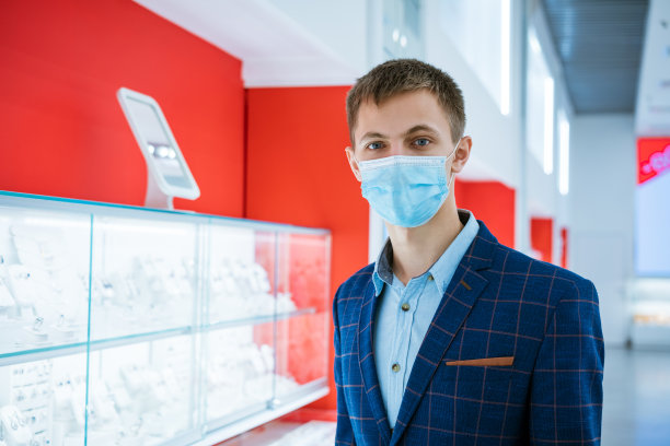 珠宝店里穿着夹克戴着医用口罩的年轻人图片下载