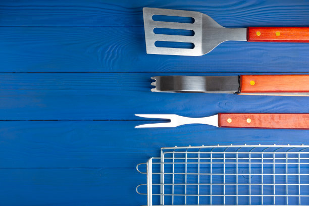 一套在蓝色纹理背景上使用的烧烤工具。图片下载
