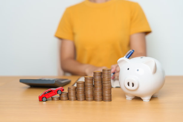 省钱，汽车保险，金融，汽车维修和保养的概念。硬币堆和存钱罐与汽车模型，钱堆计数安排存款和汽车税图片下载