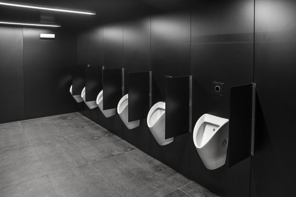 有黑色墙壁和一排白色小便池的现代公共厕所图片下载