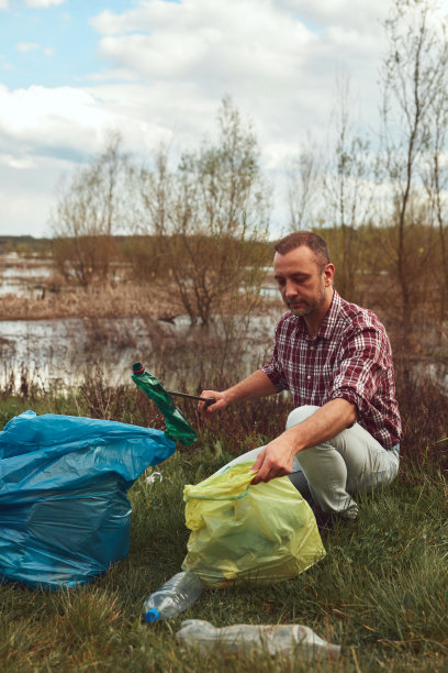 志愿者和环保人士正在清理堆满垃圾的脏湖岸。图片下载