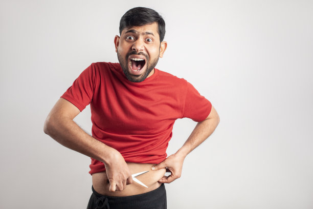 沮丧的男人减少他多余的身体脂肪图片下载