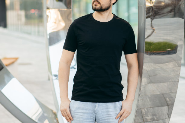 穿着黑色t恤，戴着墨镜的年轻时髦的大胡子男人。街头的照片图片下载