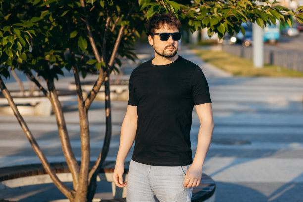 穿着黑色t恤，戴着墨镜的年轻时髦的大胡子男人。街头的照片图片下载
