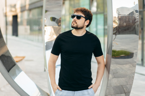 穿着黑色t恤，戴着墨镜的年轻时髦的大胡子男人。街头的照片图片下载
