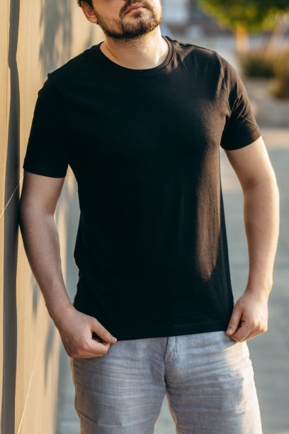 穿着黑色t恤，戴着墨镜的年轻时髦的大胡子男人。街头的照片图片下载