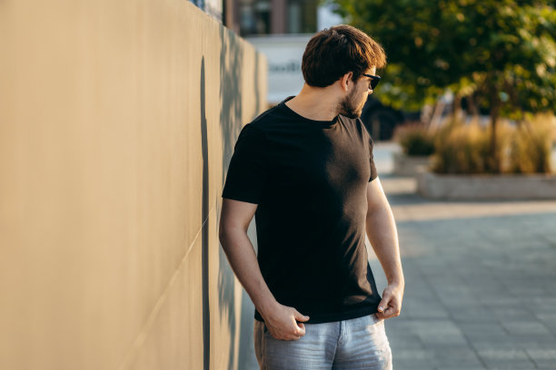 穿着黑色t恤，戴着墨镜的年轻时髦的大胡子男人。街头的照片图片下载