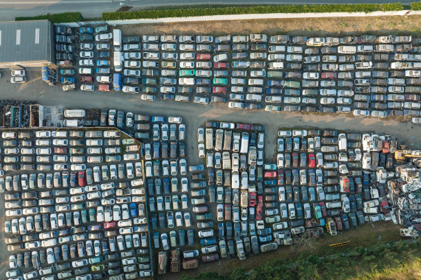 鸟瞰图:垃圾场的大停车场，一排排被丢弃的破车。回收旧车辆图片下载