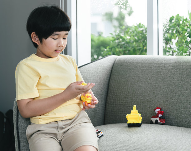 亚洲可爱男孩玩汽车玩具与父亲在家里工作图片下载