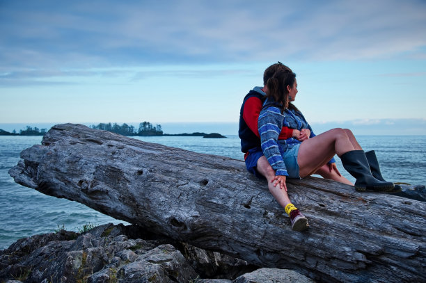 一对成熟的夫妇坐在树干上图片下载