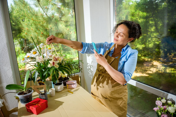 美丽的拉丁美洲孕妇，花店企业家拍摄一束兰花在柳条篮子图片下载