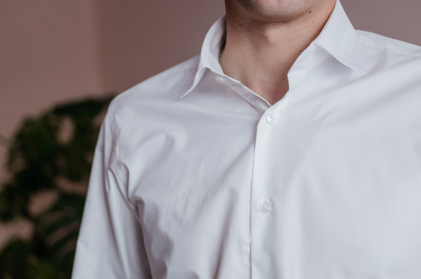 男子正在衬衫上系袖扣。新郎正在系衬衫上的袖扣图片下载