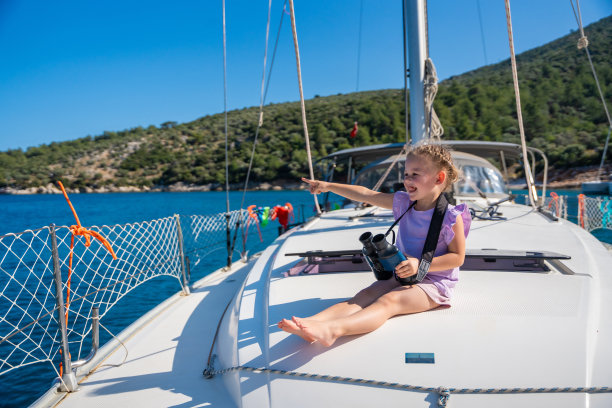 小女孩在游艇上用双筒望远镜看海图片下载