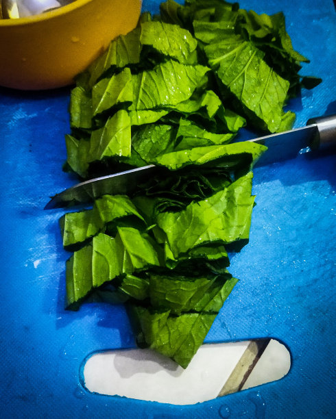图为厨房烹饪过程中，人们在餐桌上切菜的活动图片下载