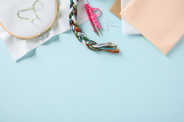 刺绣箍与空白帆布和刺绣配件在柔和的蓝色背景图片下载