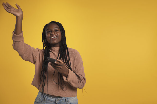 快乐的少女拿着她的智能手机，微笑着挥手图片下载