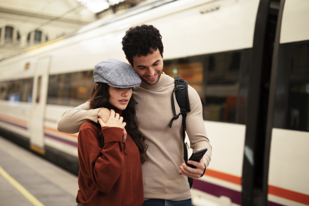 美丽的夫妇在火车站等火车。图片下载