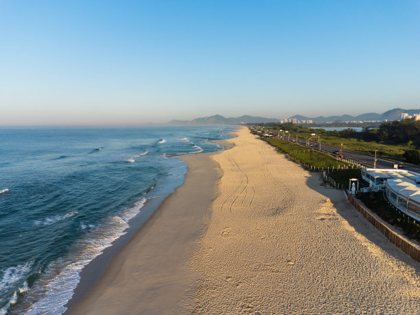 航拍Reserva海滩，Marapendi泻湖和Lucio Costa大道上的汽车交通。Barra da Tijuca和Recreio，在巴西的里约热内卢。日出。阳光明媚的一天。无人驾驶飞机的照片。普拉达珍藏图片下载
