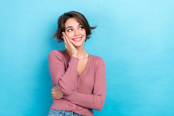 可爱的甜美的女士的照片看一边空的空间抱臂在下巴脸颊上穿粉红色的衬衫孤立的蓝色背景图片下载