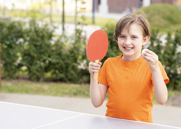 男孩手里拿着乒乓球和乒乓球用的球拍和球，准备开始比赛图片下载