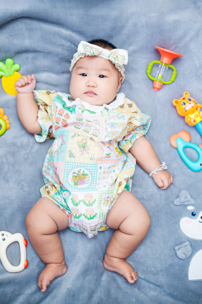 小男孩穿着花裙，六个月大的小女孩穿着可爱的衣服，头上戴着蝴蝶结图片下载