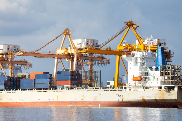 在码头、港口或港口的货船。用起重机装卸货物集装箱。商业和工业的概念，即航运，物流，国际贸易，货运和进出口。图片下载