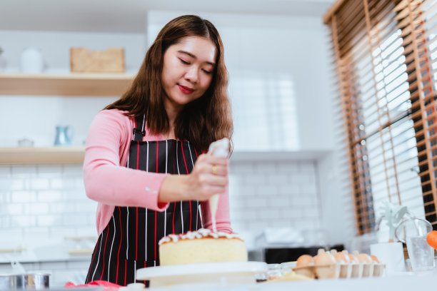 蛋糕制作，女性在厨房的艺术触觉图片下载