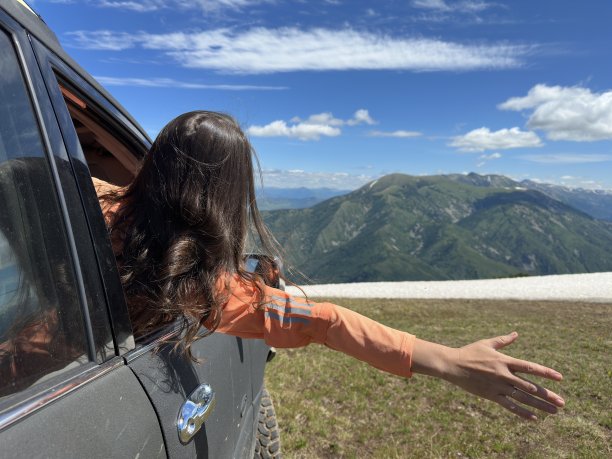 女孩从车窗向外挥手图片下载