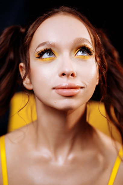 年轻的成年女子与长红色头发和自信的样子在工作室肖像图片下载