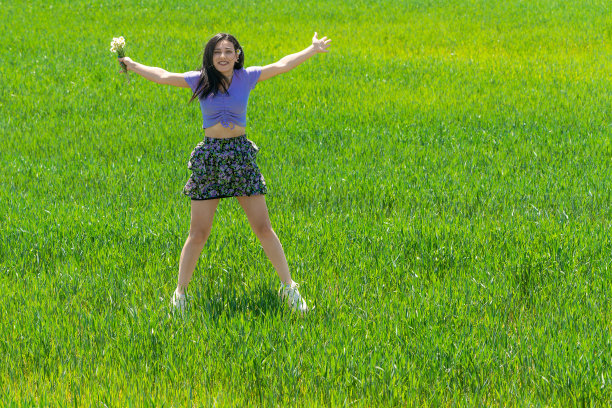 春天田野里的快乐年轻女子图片下载