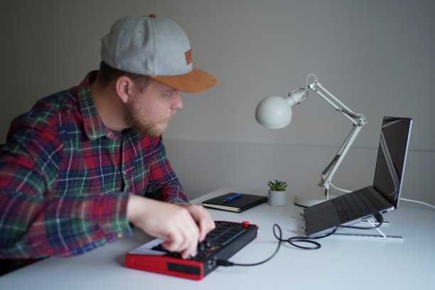 DJ在音乐工作室工作，看着笔记本电脑屏幕图片下载