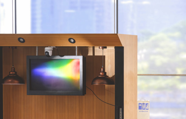 商场内美食广场区现代咖啡饮料亭悬挂电视监控面及监控摄像头的光谱反射图片下载