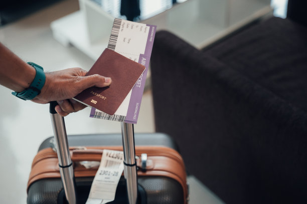 在机场手持护照和登机牌的男子特写图片下载