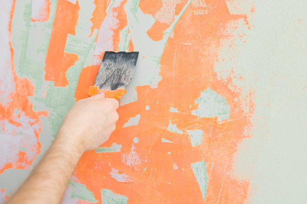 一个男人用抹刀在墙上抹洞的特写镜头图片下载