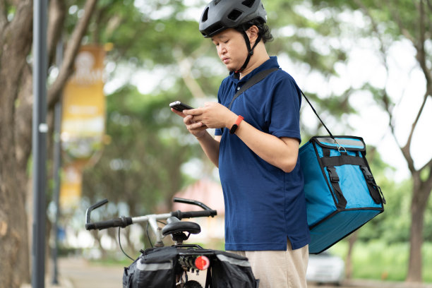自行车快递员使用智能手机图片下载