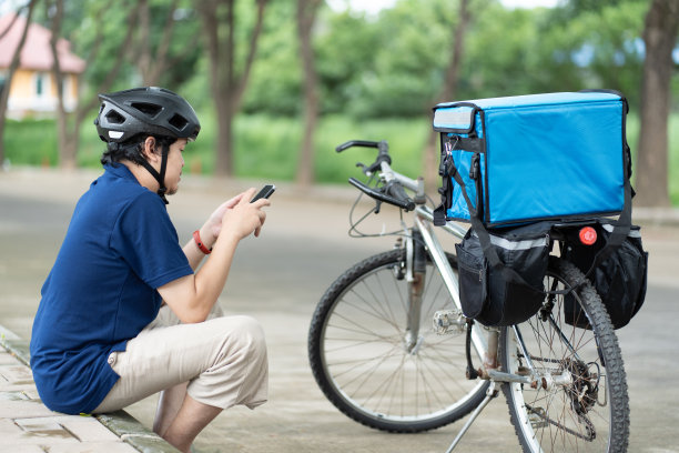 自行车快递员使用智能手机图片下载