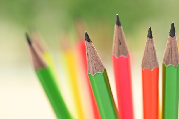 一组彩色铅笔在模糊的绿色自然背景与散景图片下载