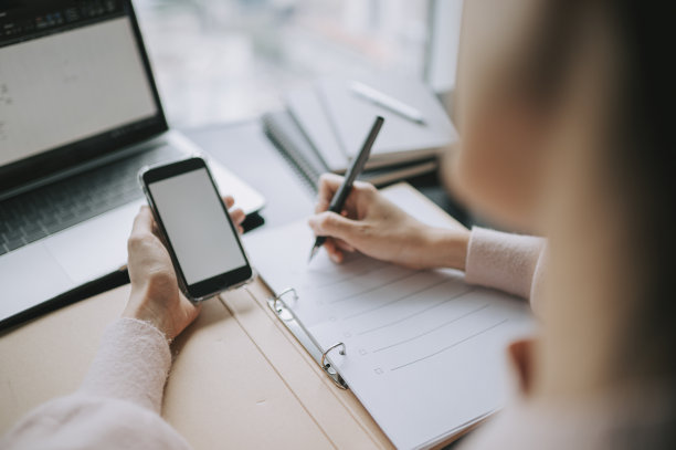 亚洲华裔女性在家里写作和使用智能手机学习工作图片下载