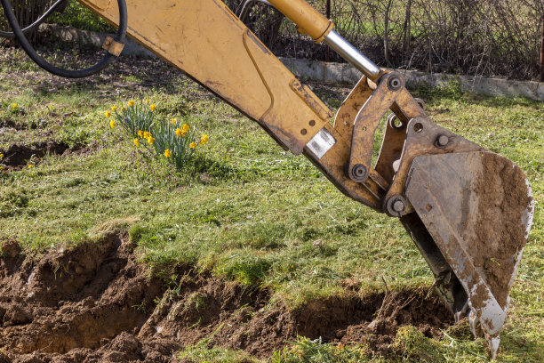 春天，挖掘机在乡间挖土图片下载