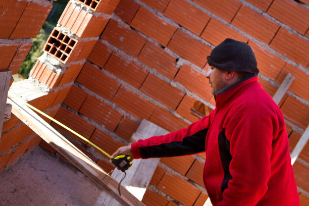 测量建筑工程中使用的木材的砖瓦工图片下载