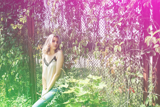 时髦的时髦女孩站在户外常春藤叶墙附近。为年轻女性拍摄时尚照片。金色短发，戴着酷酷的眼镜。图片下载