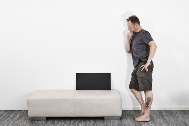 穿着短裤的男子光着脚举着黑色牌子图片下载